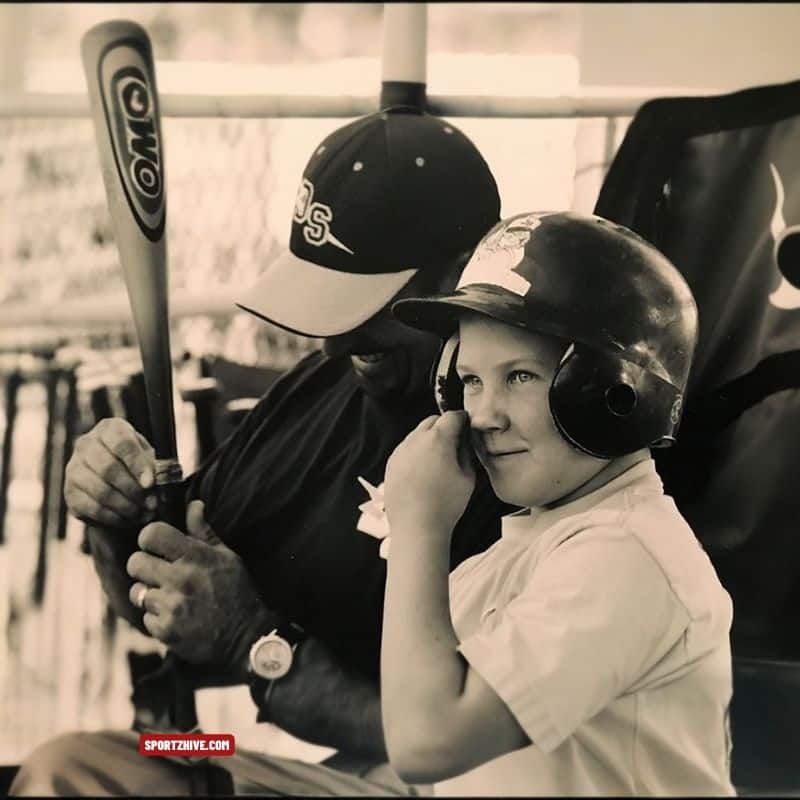 Small Bryce Harper sitting with his Dad